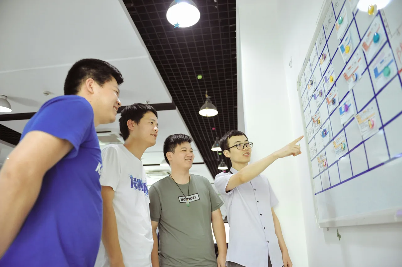 Team skizziert gemeinsam einen Ablauf am Whiteboard.